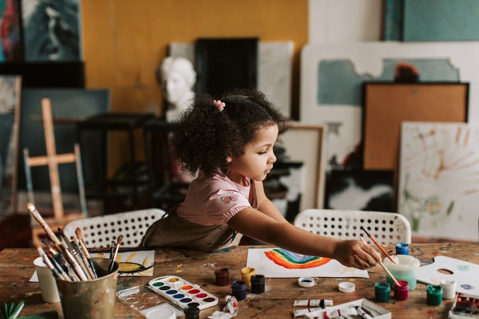 A young girl painting a rainbow in an art studio